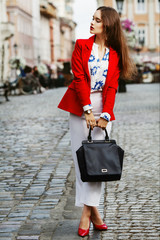Female fashion concept. Outdoor full body portrait of a young beautiful confident fashionable...