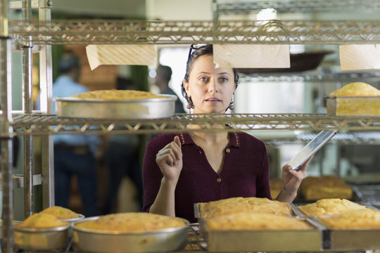 Caucasian woman using digital tablet in bakery