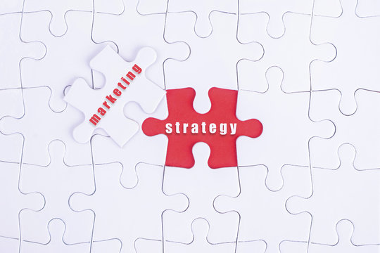 Missing white puzzle with Marketing, Strategy  word and copyspacE