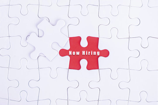 Missing white puzzle with Now Hiring word and copyspace area.
