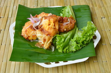 spicy deep fried egg salad on banana leaf