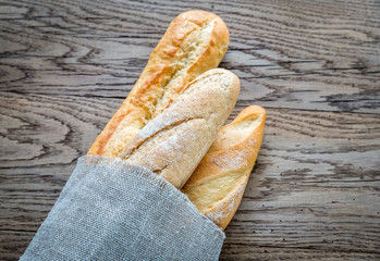 Three baguettes on the wooden background