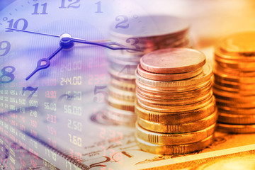 Closeup view : Stack of coins and clock hands. A concept / idea of time value of money. Money at...