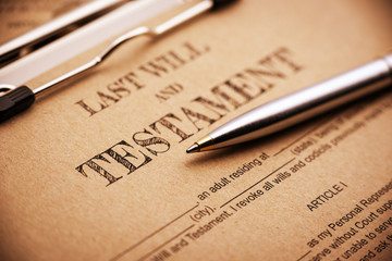 Vintage / retro style : Blue ballpoint pen and a last will and testament on a clip board. A form is...
