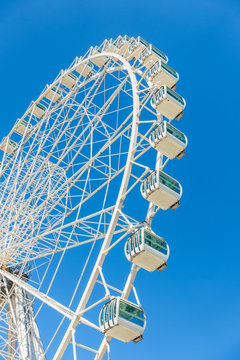 Close-up of white ferris wheel against of clear blue sky