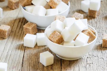 White and cane sugar in a porcelain bowls, selective focus