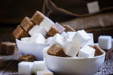White and cane sugar in a porcelain bowls, selective focus