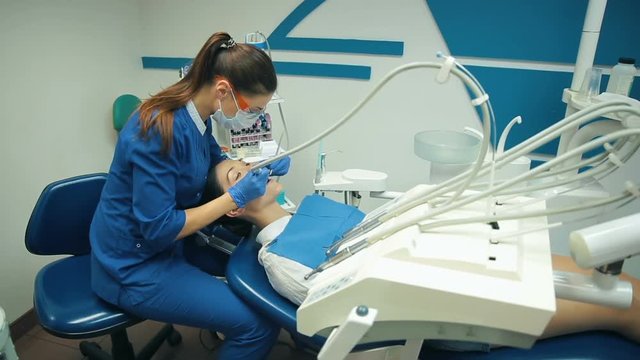 Young Woman treats teeth at the dentist