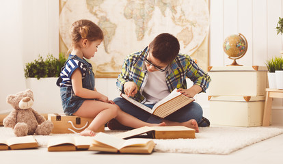children brother and sister, boy and girl reading a book