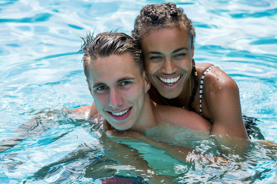 Young Mixed Couple In A Swimming Pool