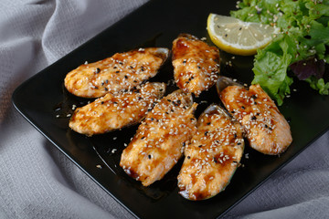 baked mussels with cheese on on black dish