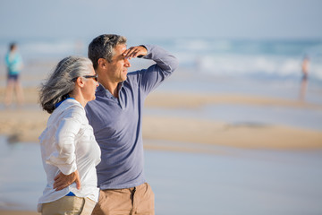 mid aged couple laying out on the beach