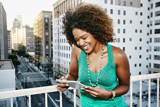 Mixed race woman using digital tablet on urban rooftop