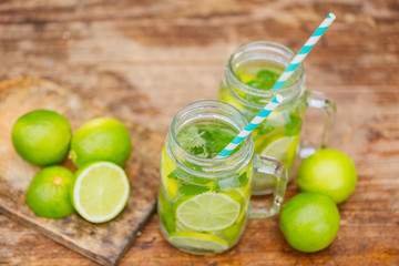 Fresh drink lemonade mojito in mason jar on wooden background.