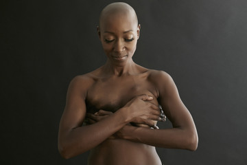 Female cancer survivor covering breasts