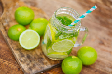 Fresh drink lemonade mojito in mason jar on wooden background.