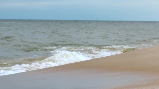 Ujęcie na burzliwy brzeg morza gdzie oblewają go wysokie fale na pustej plaży, nie ma żadnej osoby na horyzoncie