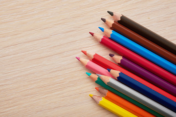 colored pencils lying on a wooden desk