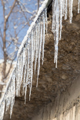 icicles on a roof of a house in winter