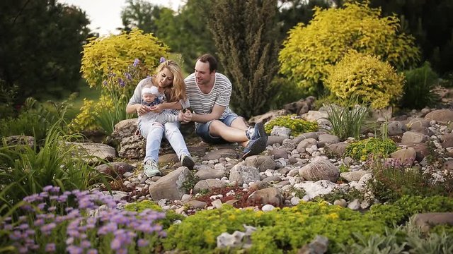 Young family relaxing in the park on the grass.