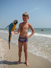 a child with a parrot on his shoulder