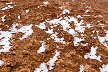 snow on red clay in nature