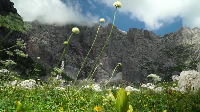 Flight of the Camera Along a Stone Against High Mountains and the Blue Sky