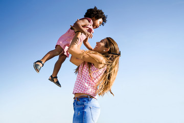 Beautiful young mother with her son having fun in the park.