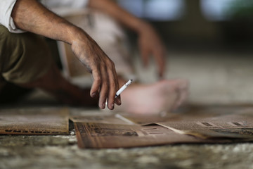 Dirty man hand holding a cigarette with smoke. Working man enjoy