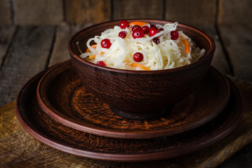 Sauerkraut with berries in clay bowl. Top wiev. Autumn concept