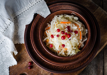 Sauerkraut with berries in clay bowl. Top wiev. Autumn concept
