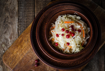 Sauerkraut with berries in clay bowl. Top wiev. Autumn concept