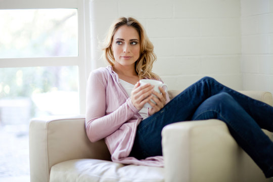 Caucasian woman sitting in chair drinking coffee
