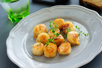 Scallops fried in cream sauce with herbs.