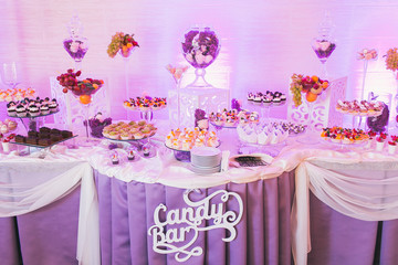 Candy bar, decorated table with sweets and flowers, baked goods