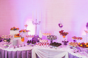 Candy bar, decorated table with sweets and flowers, baked goods