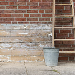 conductor and bucket / weathered wood surface with ladder, bucket, broom and shovel