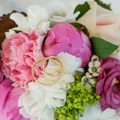 wedding rings / Bridal bouquet with pink and white flowers and golden wedding rings