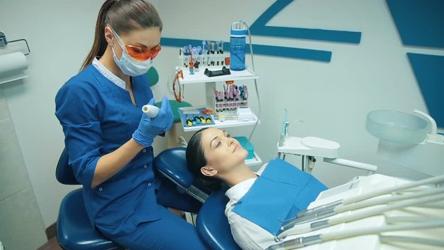 Dentis puts dental fillings with blue light