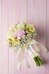 pink and ivory wedding bouquet on pink wooden background, gift for holidays and celebration