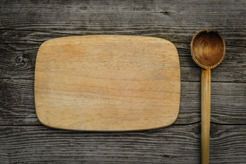Cutting board on rustic wooden background. Top view
