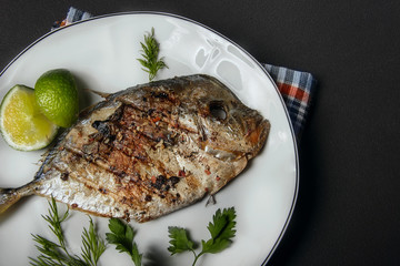 Grilled fish (Vomer) lime ,dill,parsley on the white plate.close