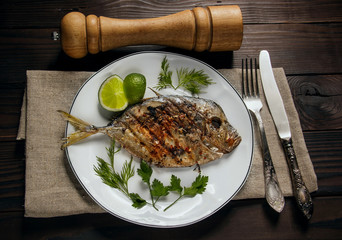 Grilled fish (Vomer) lime ,dill,parsley on the white plate with