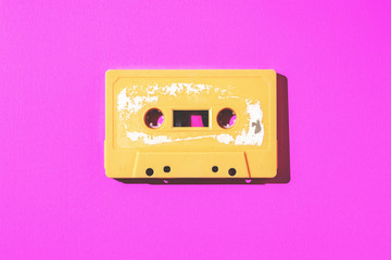 Fototapeta premium Old cassette tape on pink paper with copy space