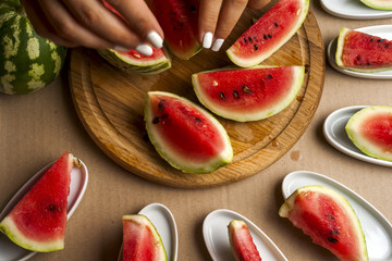 Slices of watermelon. Children's hands cooking fruit salad. Top view
