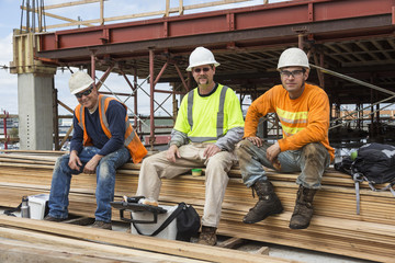 Portrait of smiling workers sitting at construction site