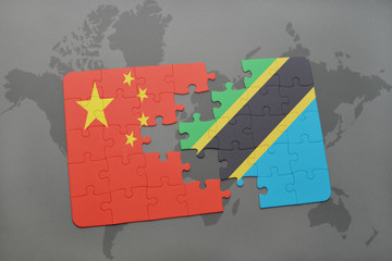 puzzle with the national flag of china and tanzania on a world map background.