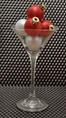 Red and silver Christmas tree baubles in a martini glass isolate