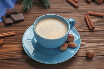 Cup of coffee with nuts on wooden table