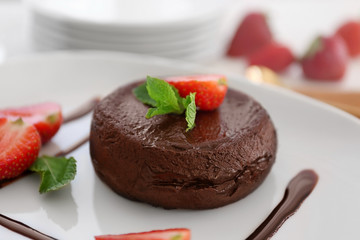 Chocolate fondant with strawberry on plate, closeup